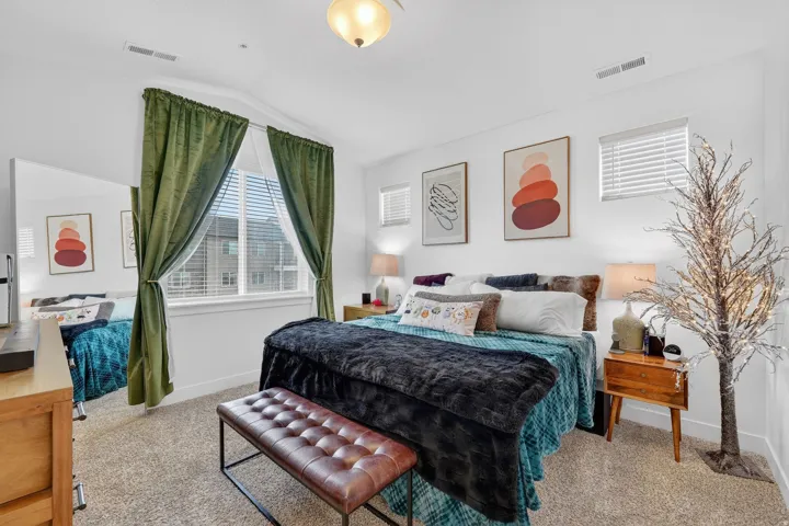 Bedroom with vaulted ceiling and light colored carpet