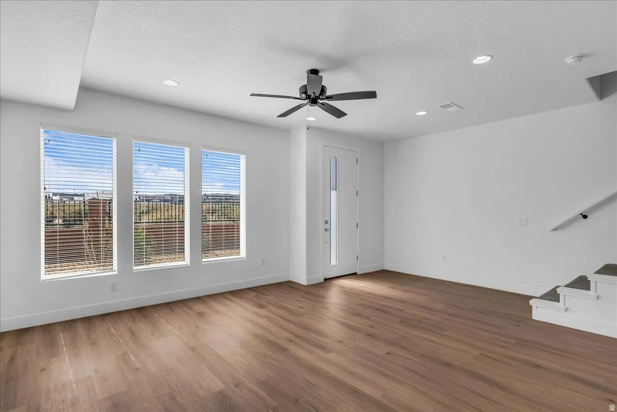 Unfurnished living room with ceiling fan, dark wood-style floors, recessed lighting, and a textured ceiling