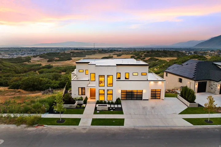 Modern home featuring concrete driveway, stucco siding, and a mountain view