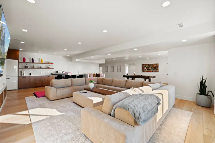 Living area with light wood-type flooring and recessed lighting