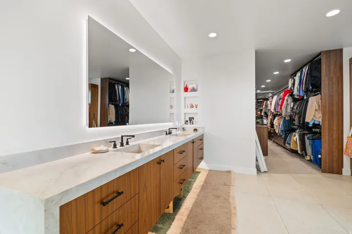 Full bath featuring a spacious closet, double vanity, recessed lighting, and light tile patterned floors