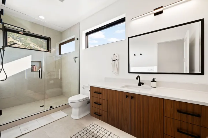 Bathroom with a shower stall, vanity, plenty of natural light, and light tile patterned flooring