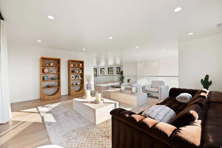 Living area with light wood-style floors and recessed lighting