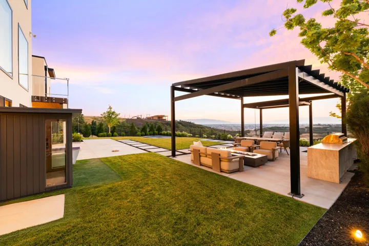 Yard at dusk with an outdoor living space with a fire pit, a yard, and a patio area