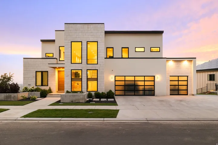 Contemporary home featuring concrete driveway, stucco siding, and a garage