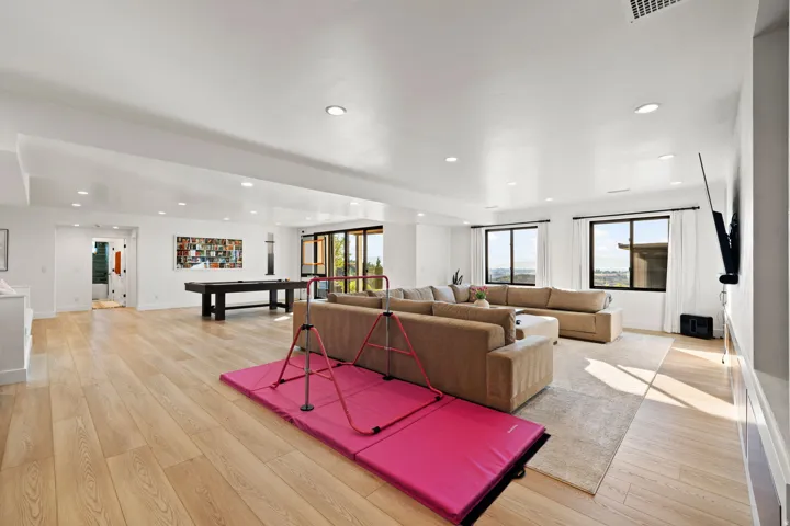 Living area with billiards table, light wood-style flooring, and recessed lighting