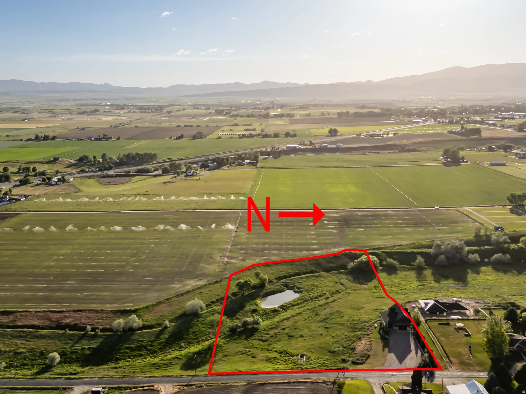 Aerial perspective showcasing a parcel of land outlined in red