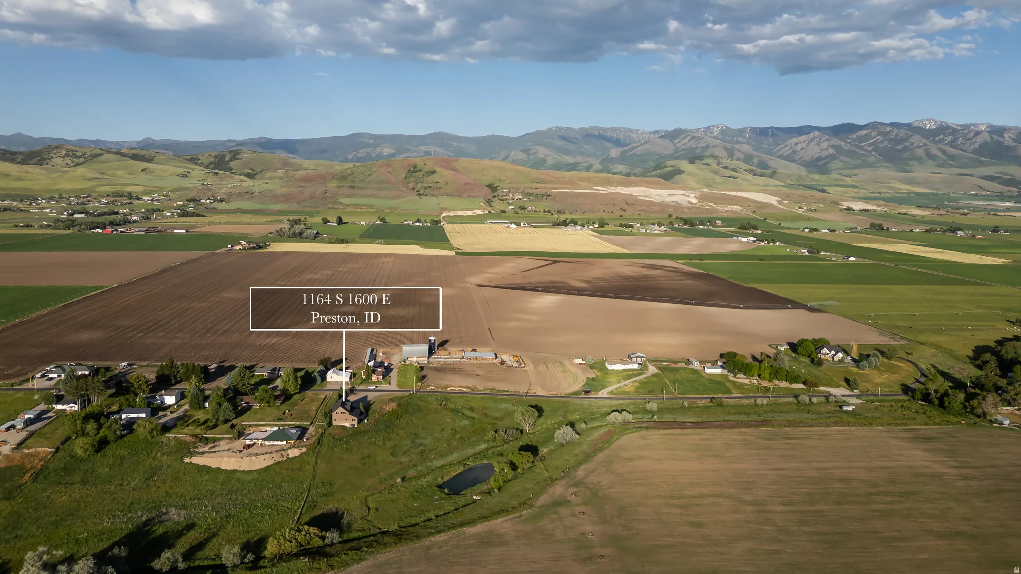 Expansive rural property featuring substantial agricultural land and distant mountain ranges