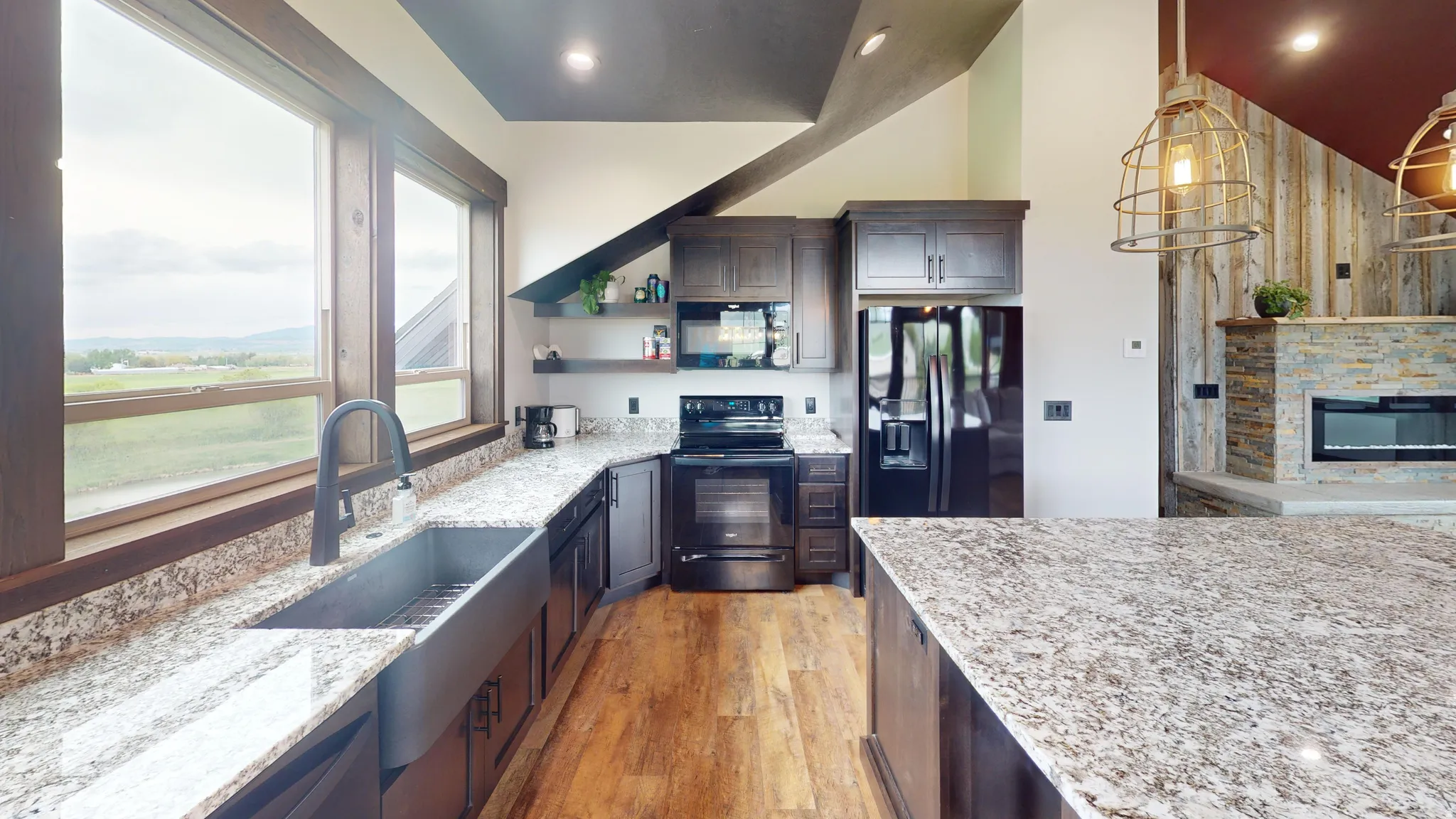 Kitchen with open shelves, light stone countertops, black appliances, light wood-style floors, and dark wood finish cabinets