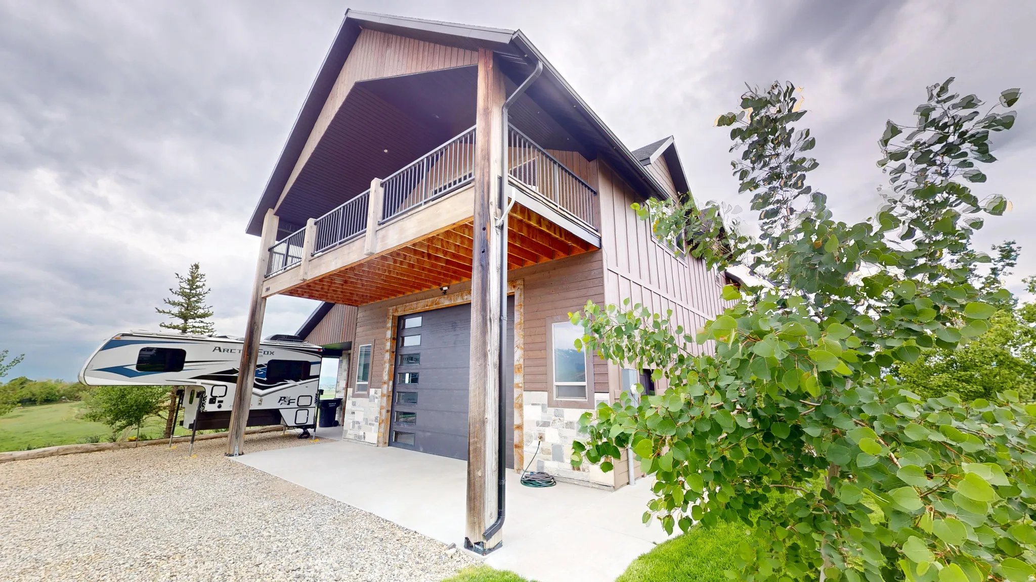 View of front of property with a patio area, board and batten siding, an attached garage, and gravel driveway