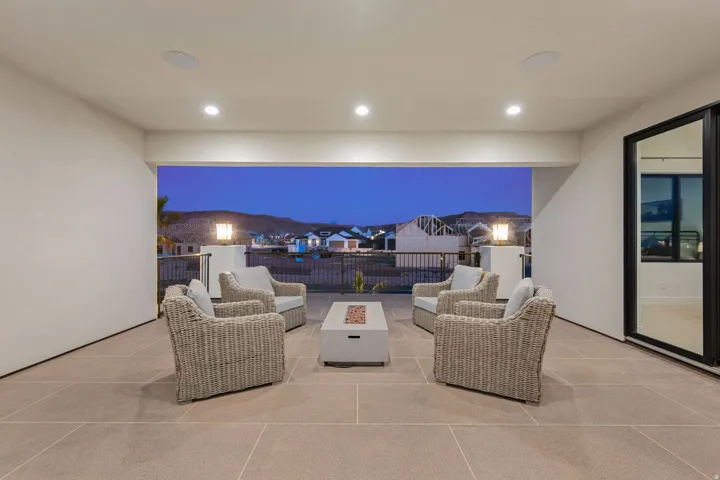 Patio at night featuring a patio area, an outdoor living space with a fire pit, and a residential view