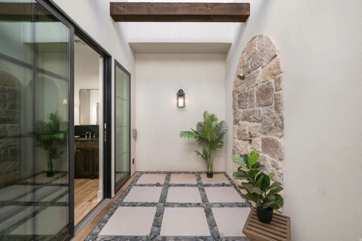 View of exterior entry with stucco siding and stone siding