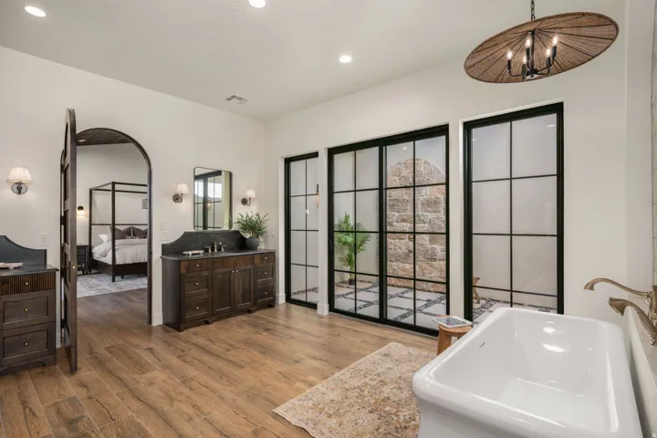 Ensuite bathroom featuring vanity, dark wood-style floors, a tub to relax in, and recessed lighting