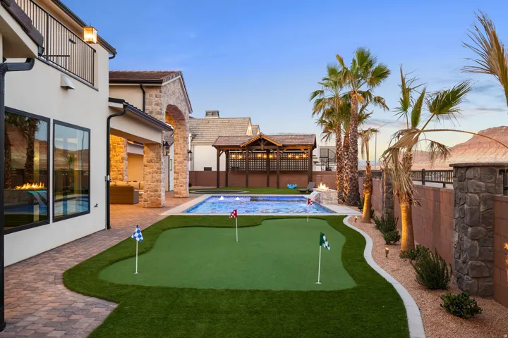 Fenced backyard with a patio and a putting area