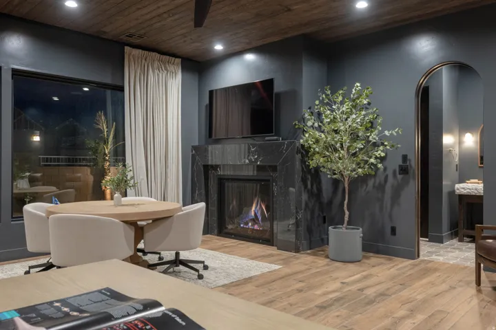 Living room featuring arched walkways, light wood finished floors, recessed lighting, a premium fireplace, and wooden ceiling