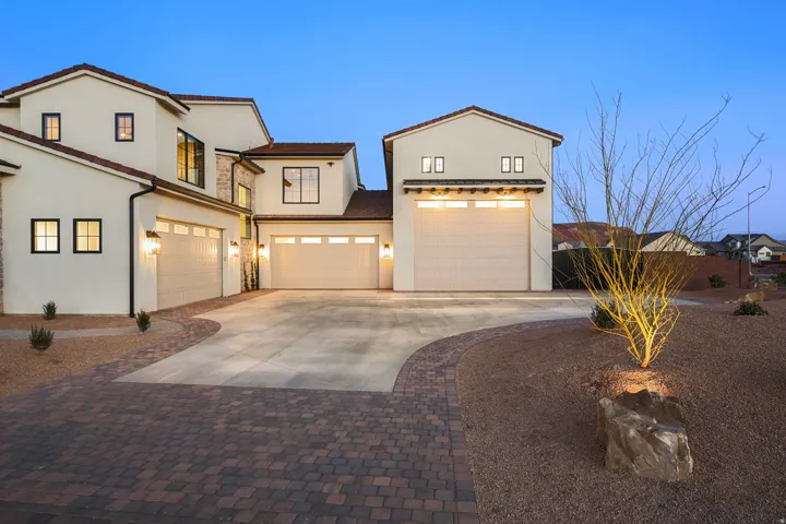 Mediterranean / spanish-style house with concrete driveway, an attached garage, and stucco siding