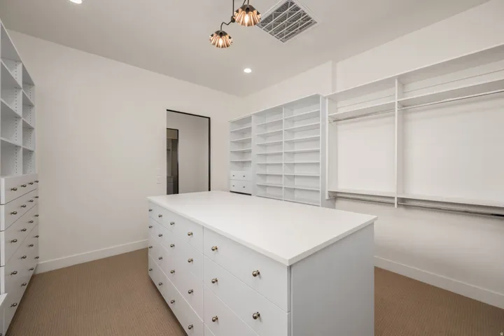 Walk in closet with dark colored carpet