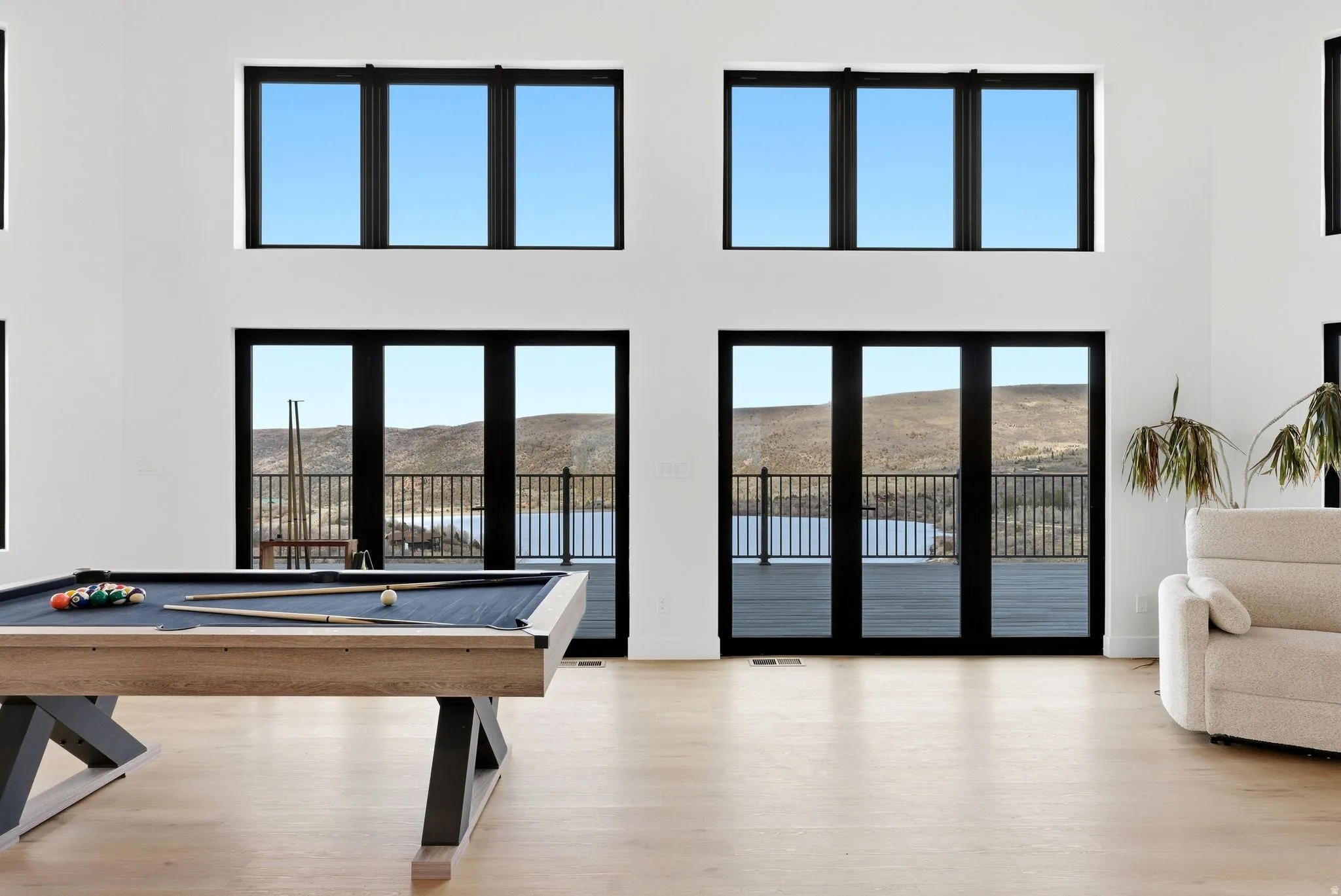 Game room with billiards, light wood-type flooring, a mountain view, and a high ceiling
