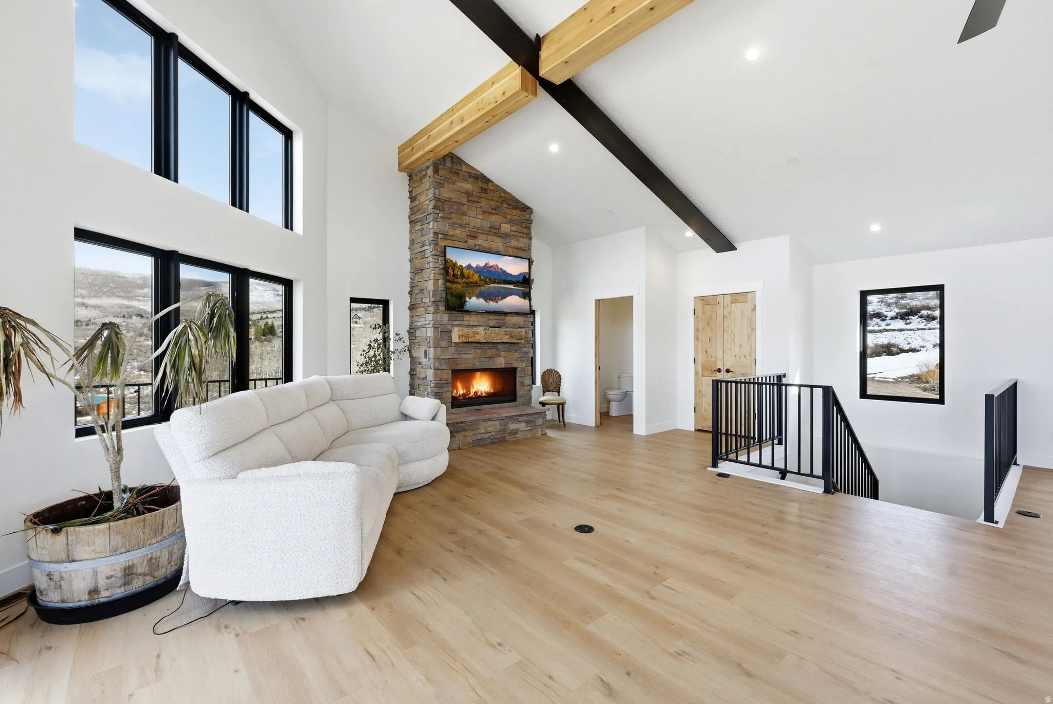 Living room featuring a fireplace, light wood-style flooring, and vaulted ceiling
