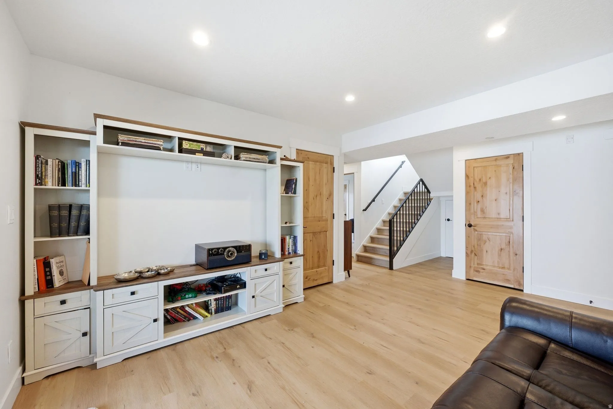 Living area featuring light wood finished floors and recessed lighting