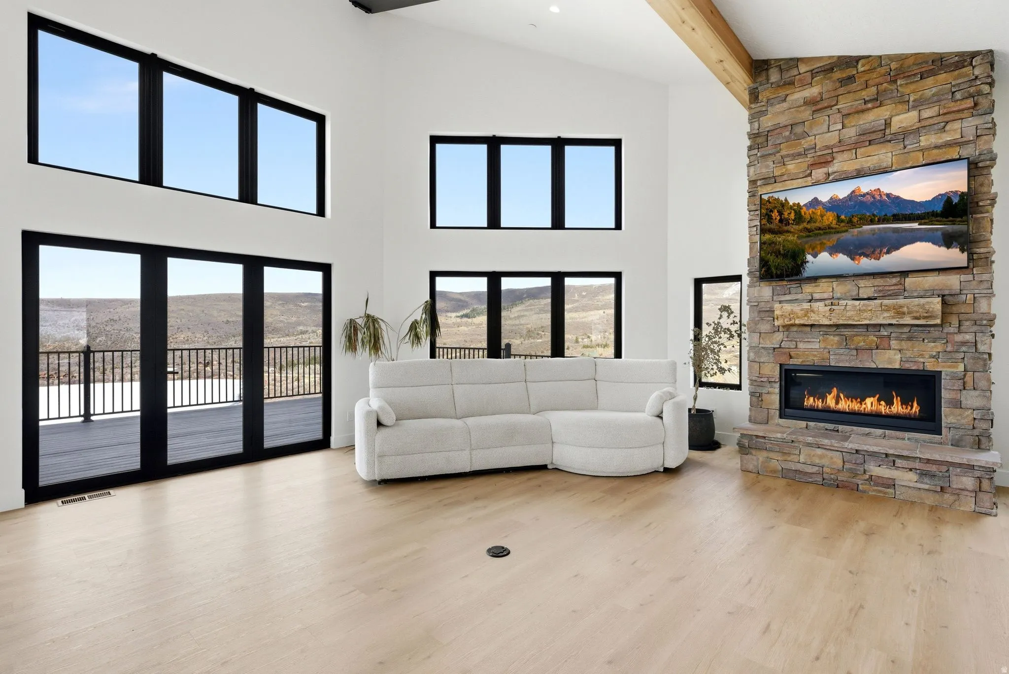 Living area with a fireplace, light wood-type flooring, and vaulted ceiling