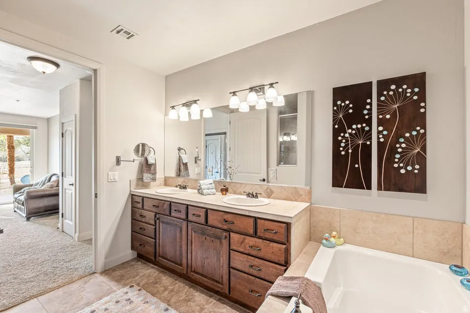 Bathroom with double vanity, a garden tub, light carpet, light tile patterned flooring, and walk in shower