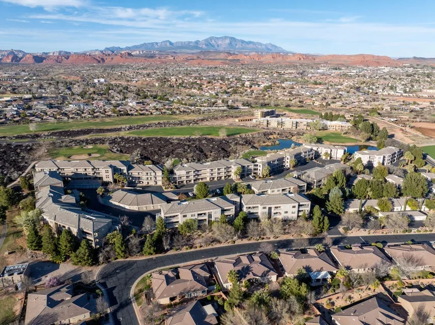 Aerial view of residential area with a mountainous background and a golf course