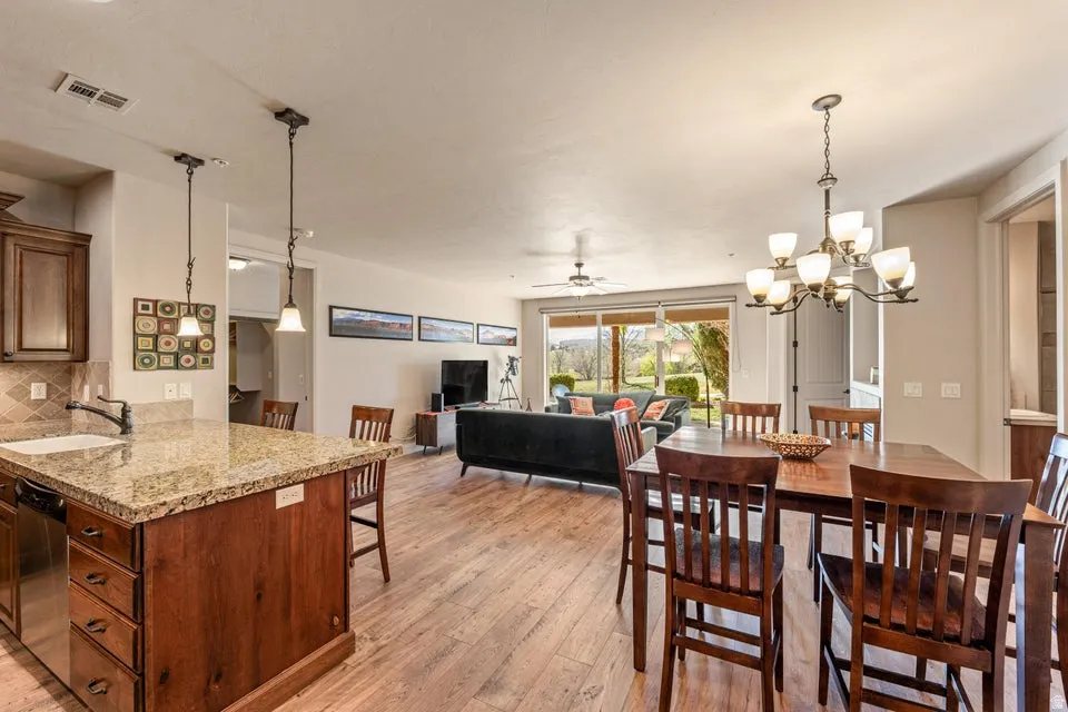 Dining space with suspended lighting, a ceiling fan, and light wood-style floors