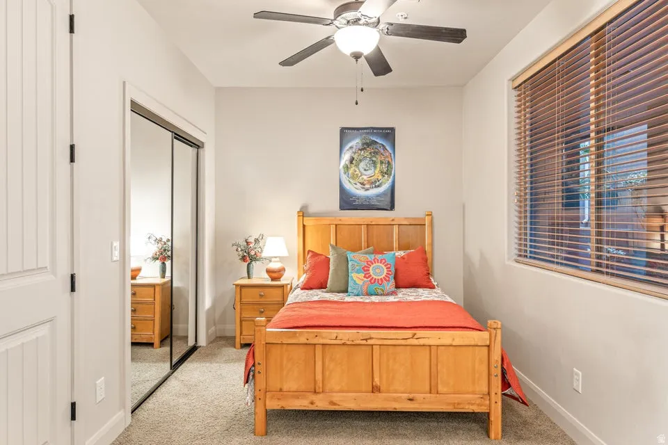 Bedroom featuring carpet, a closet, and a ceiling fan
