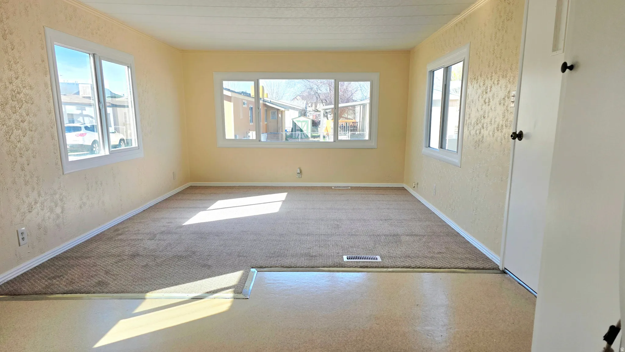Unfurnished room featuring carpet floors and a textured wall