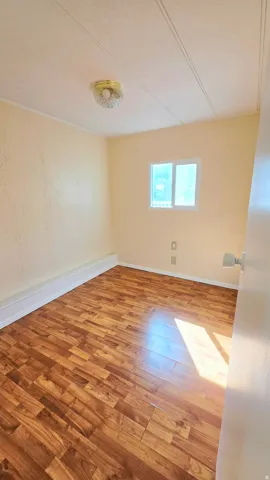 Spare room with light wood-type flooring and a textured ceiling