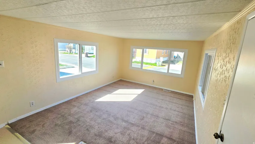 Carpeted spare room with a textured wall and ornamental molding