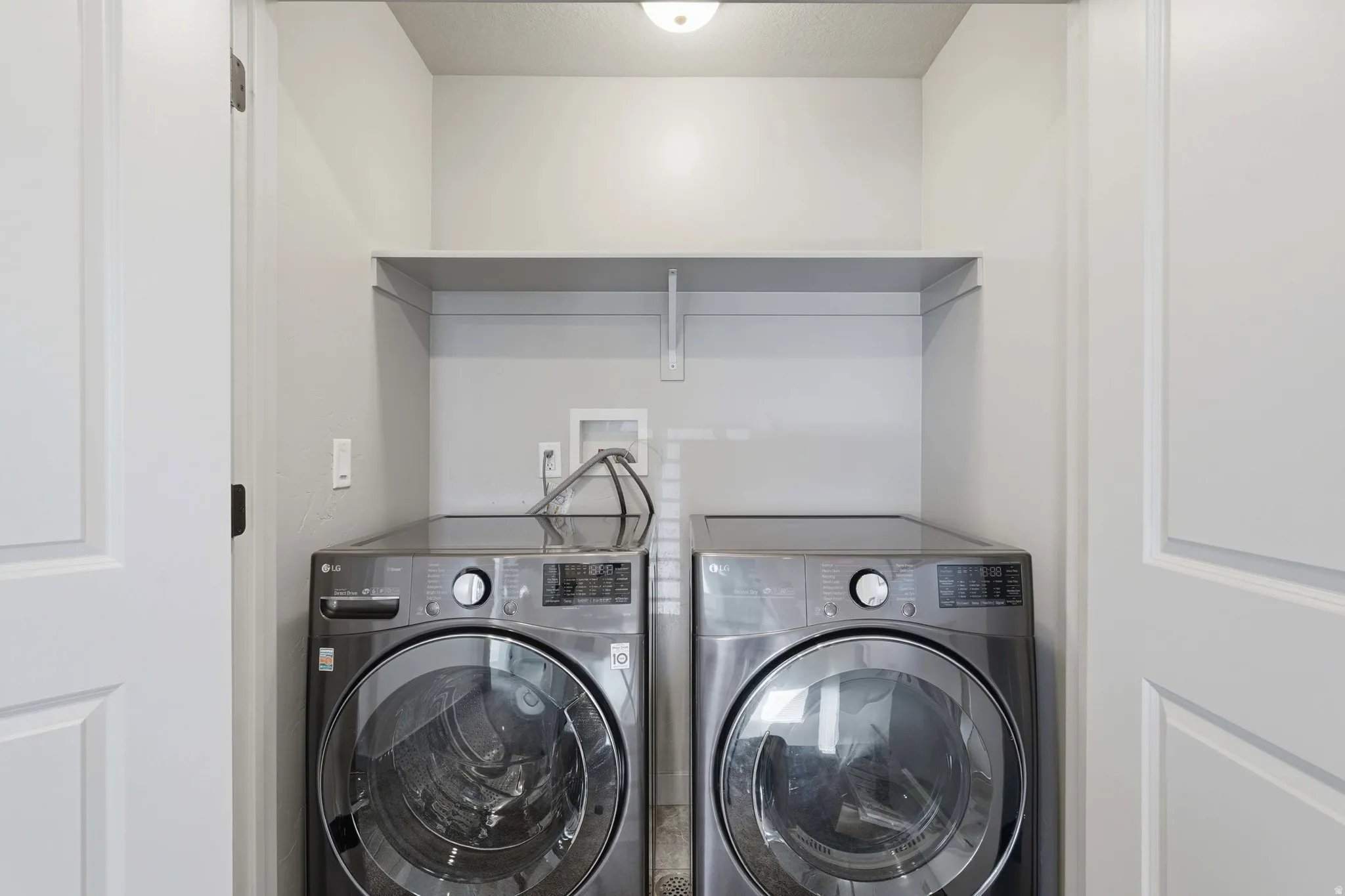Laundry area featuring separate washer and dryer and a textured ceiling