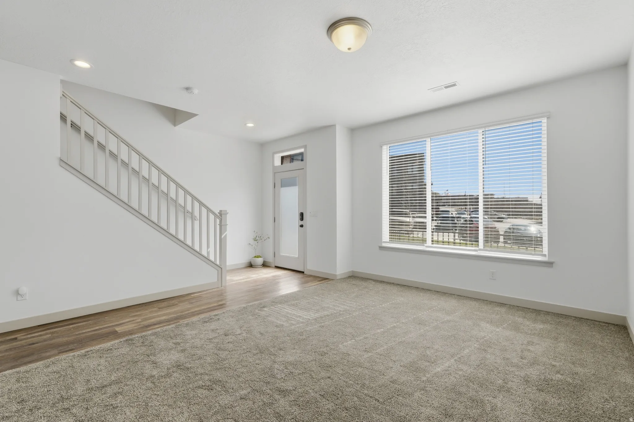 Entryway featuring stairway and light carpet