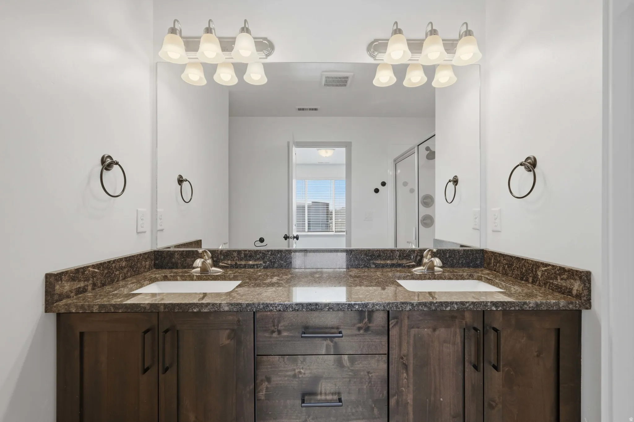 Primary Bathroom featuring double vanity and a stall shower