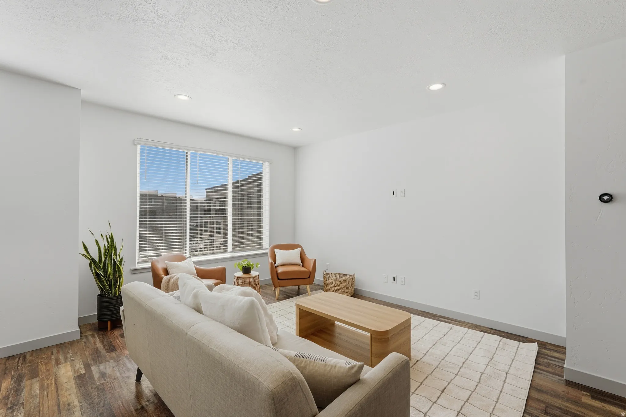 Family room with dark wood-style flooring, a textured ceiling, and recessed lighting