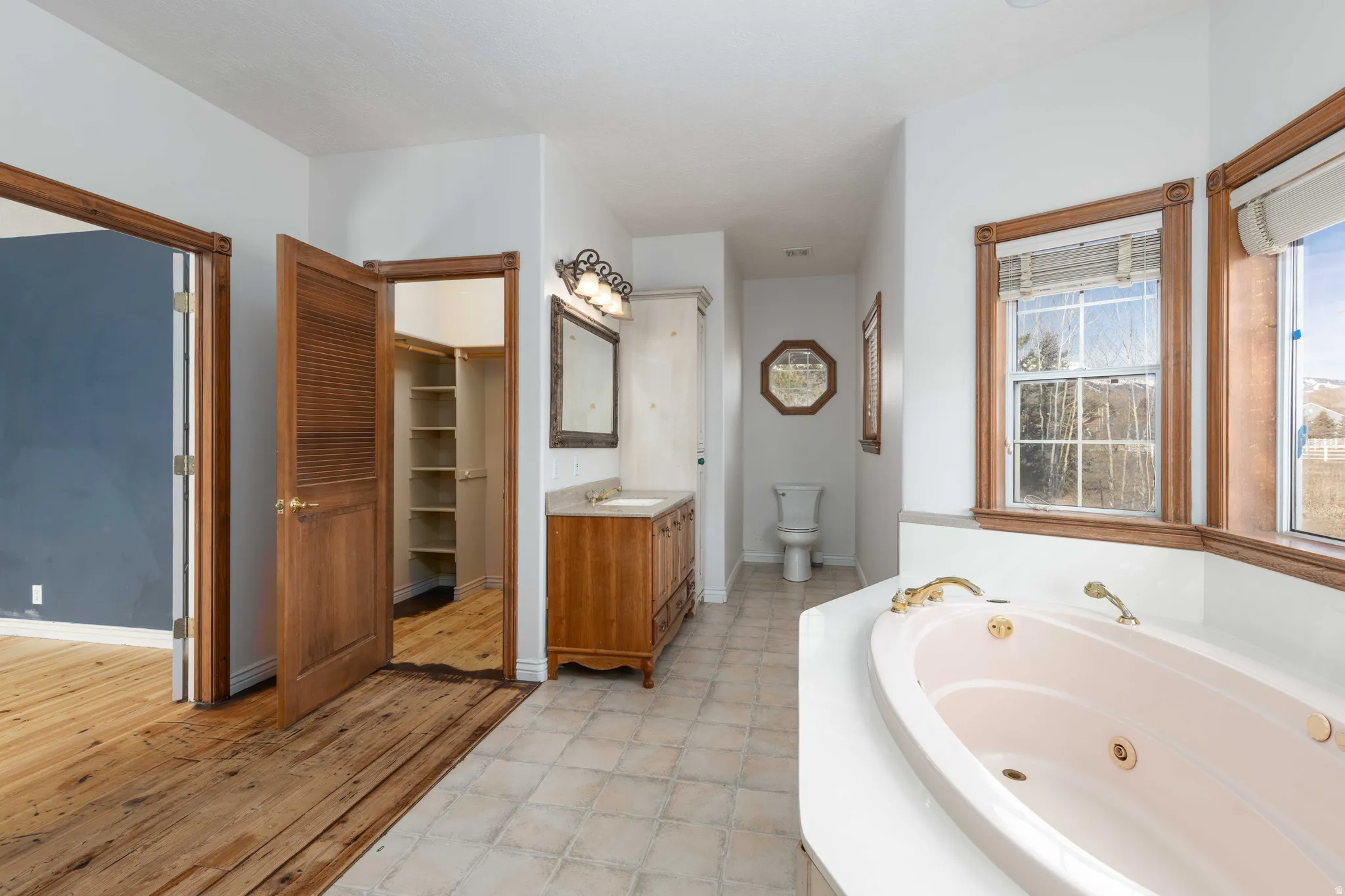 Primary Full bath featuring vanity, a jetted tub, and two spacious closet.
