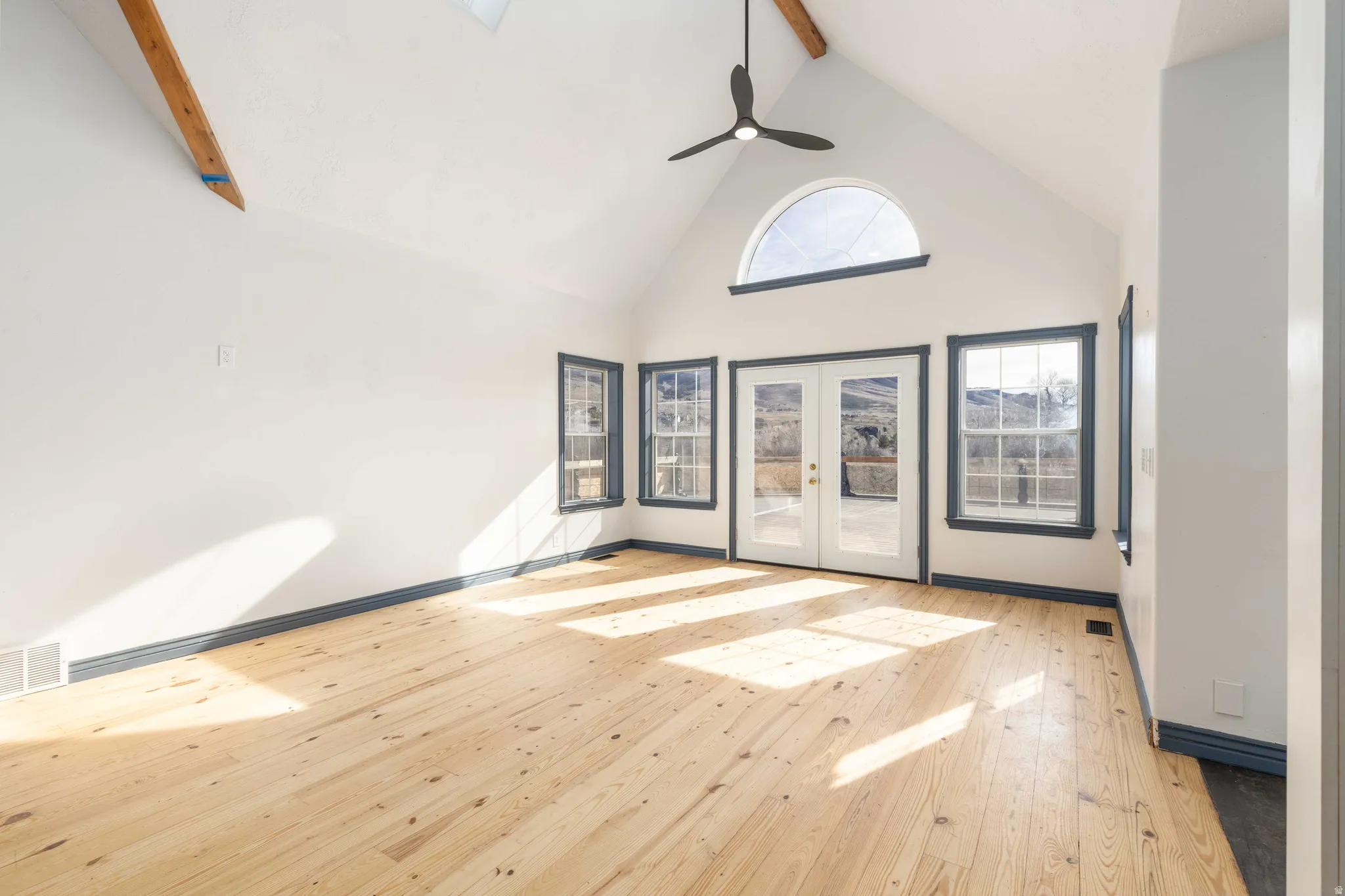 Spare room featuring french doors, light wood-style flooring, and a ceiling fan