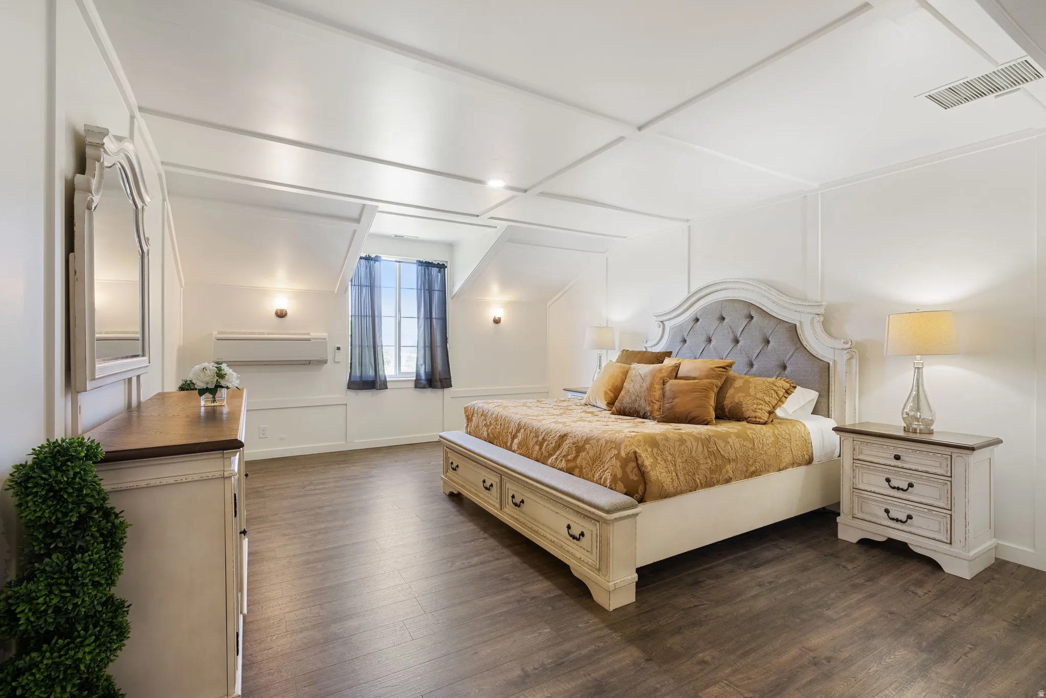 Bedroom with dark wood finished floors and a decorative wall