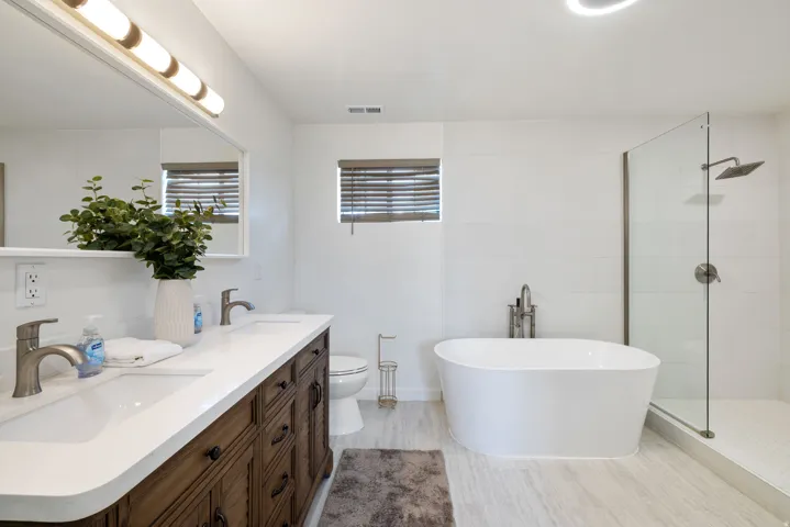 Bathroom with walk in shower, a freestanding bath, and double vanity