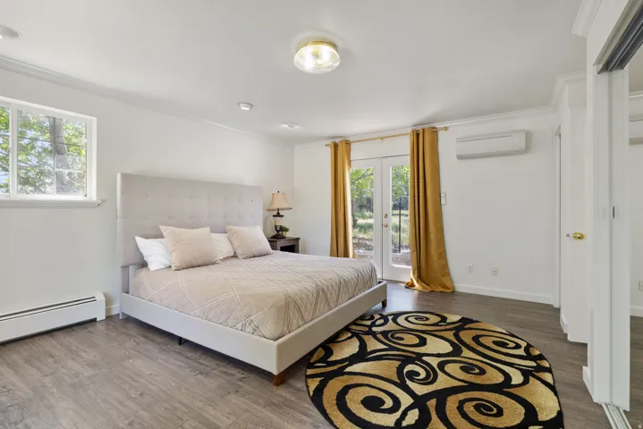 Bedroom with french doors, dark wood finished floors, ornamental molding, and access to exterior