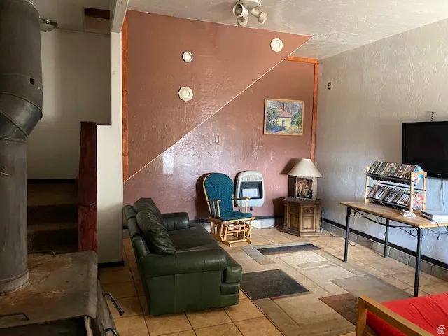 Living area with a textured wall, heating unit, and tile patterned floors