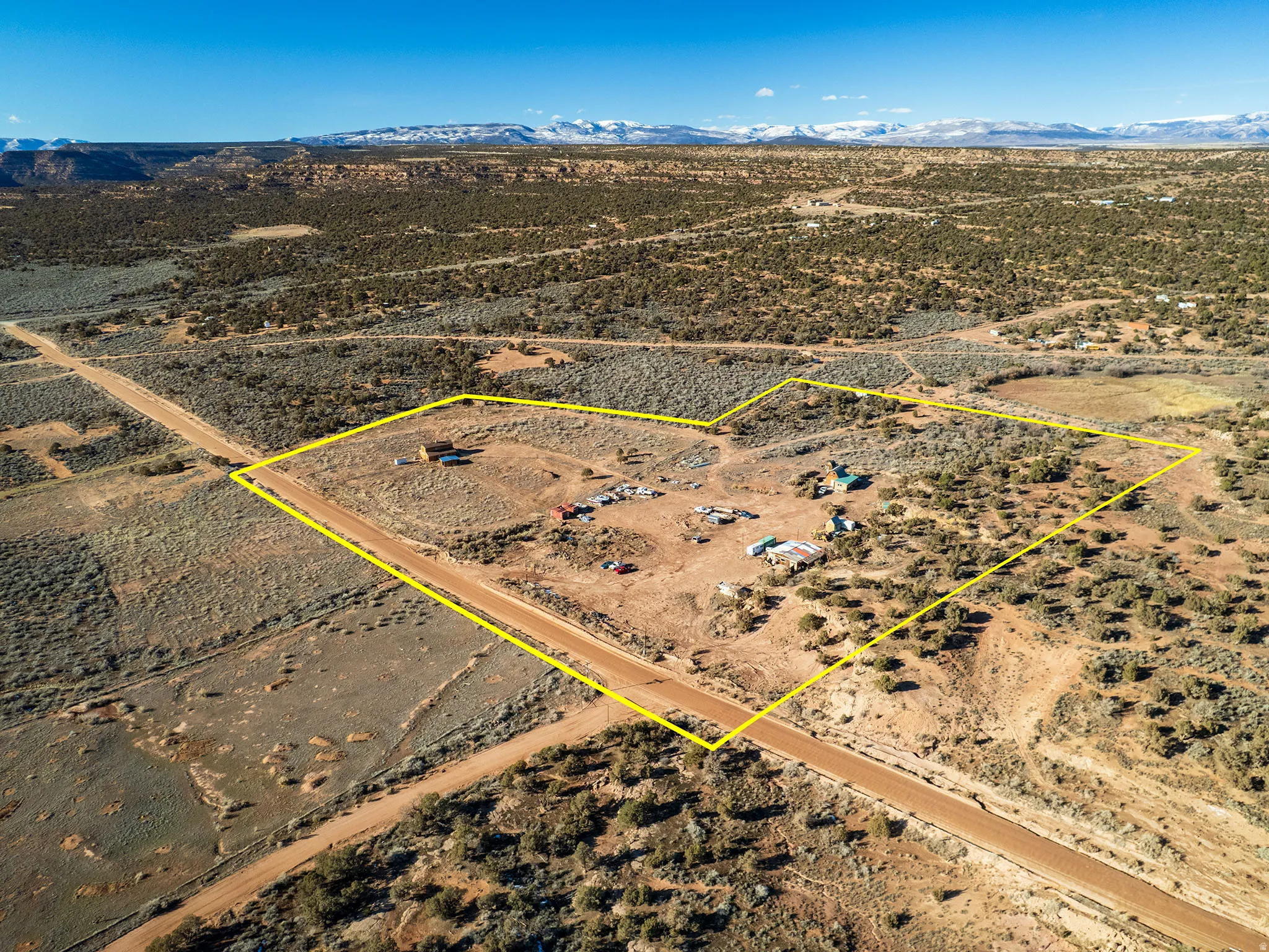 Aerial view of sparsely populated area featuring property parcel outlined and a mountainous background