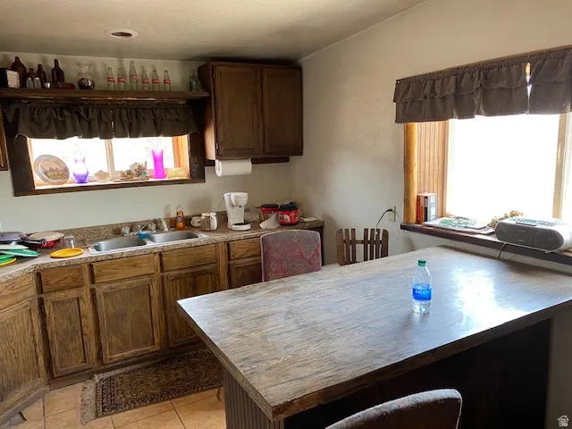 Kitchen with plenty of natural light, a breakfast bar, and light tile patterned floors