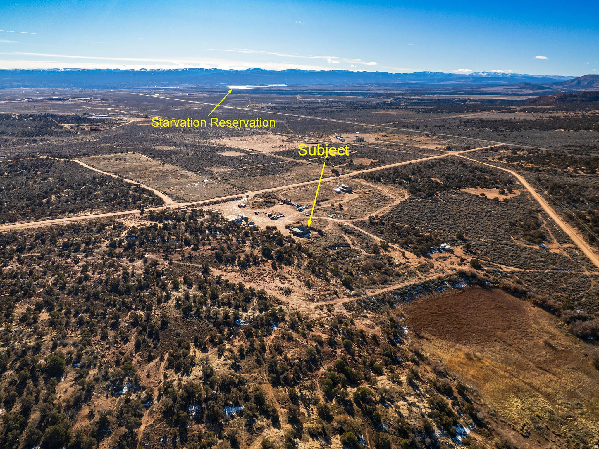 Aerial view of sparsely populated area with a mountain backdrop and a desert landscape