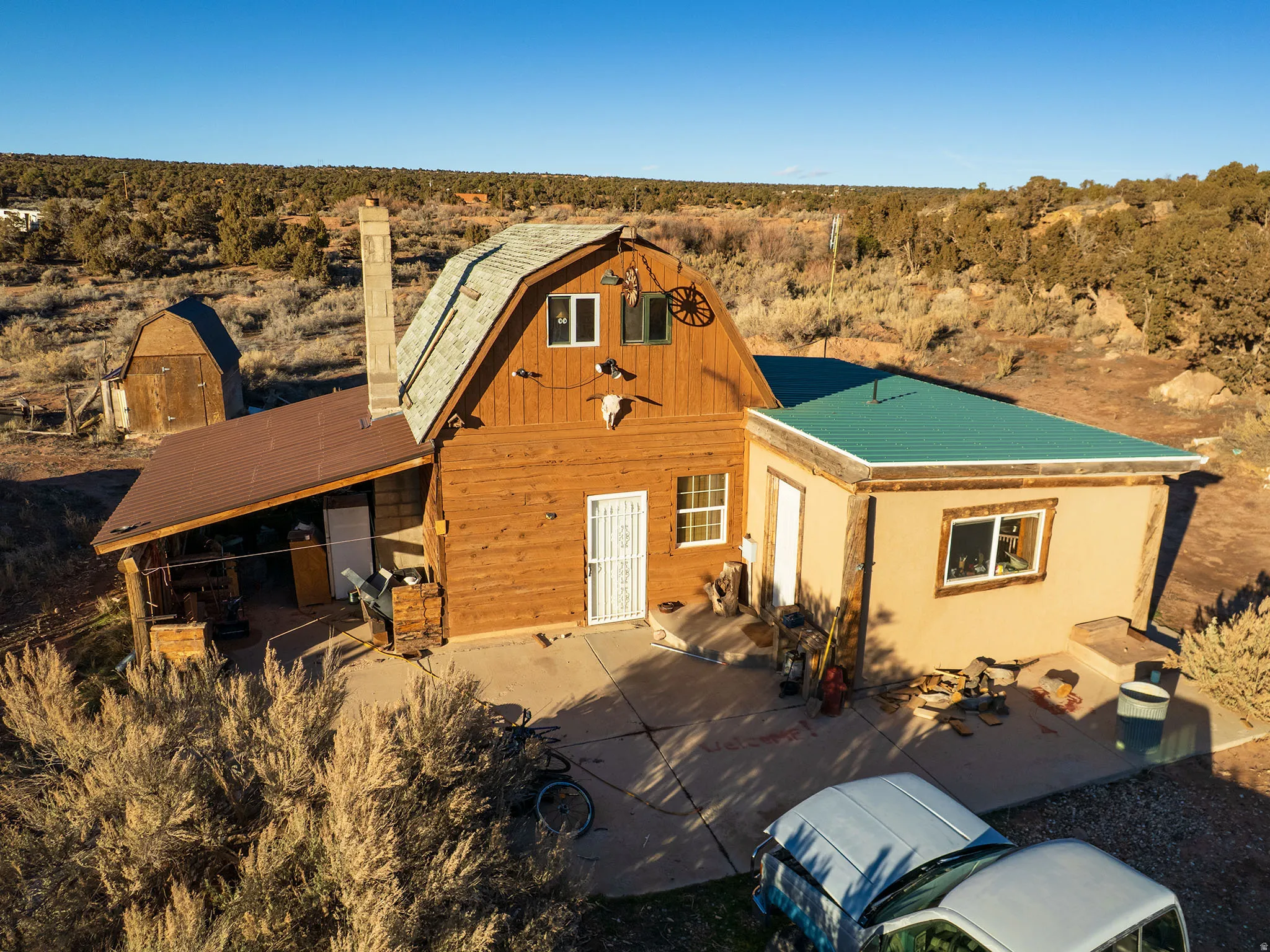View of front of property featuring a desert view, a patio area, a rural view, and a chimney