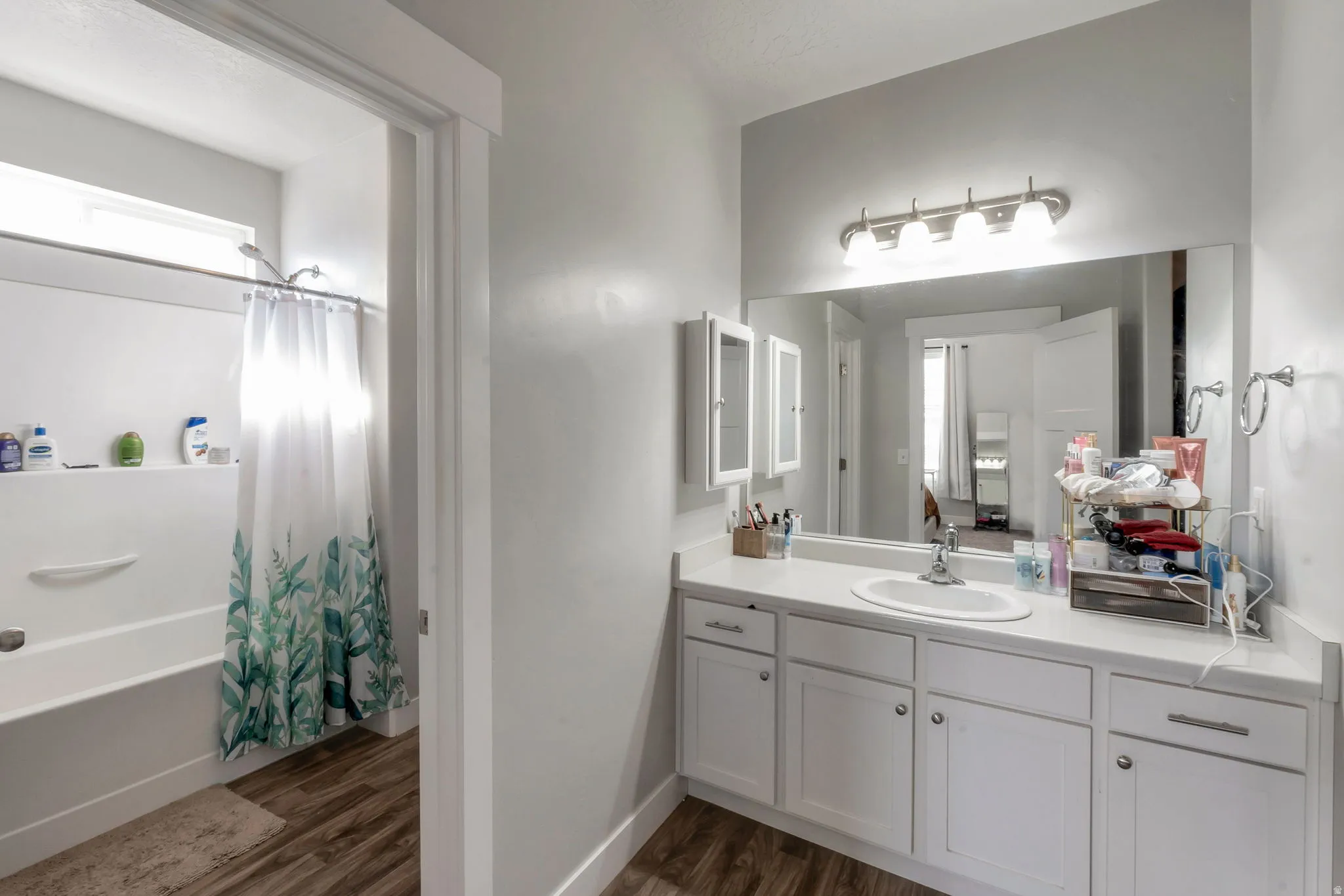 Full bath featuring vanity, dark wood-style flooring, and shower / bath combo