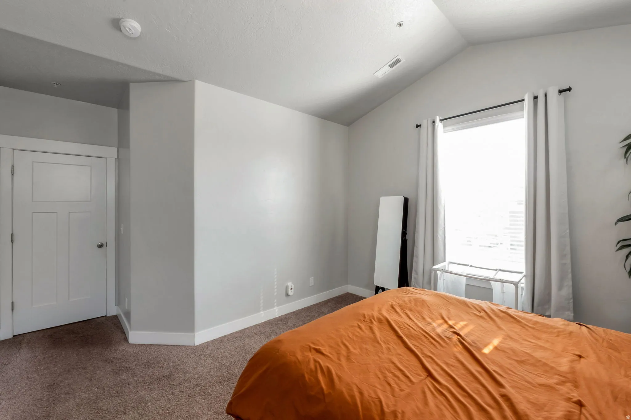 Bedroom featuring vaulted ceiling and dark carpet