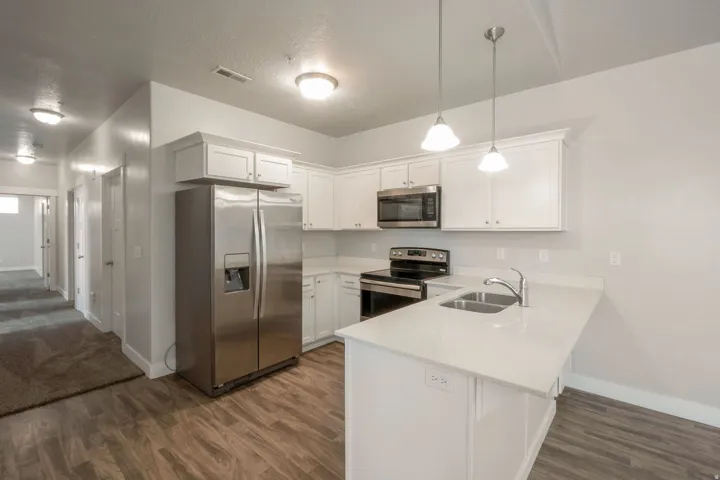 Contemporary kitchen featuring white cabinetry, stainless steel appliances, and light-toned countertops