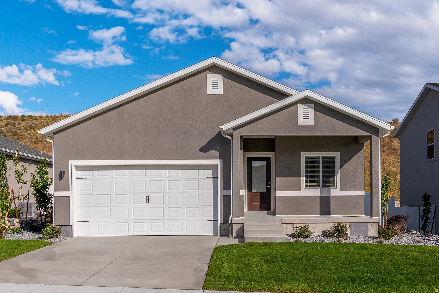 Single story home featuring covered porch, a garage, and stucco siding